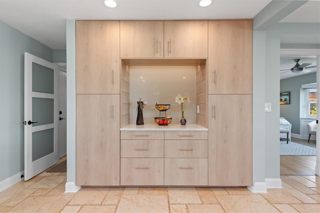 bar with ceiling fan and light brown cabinets