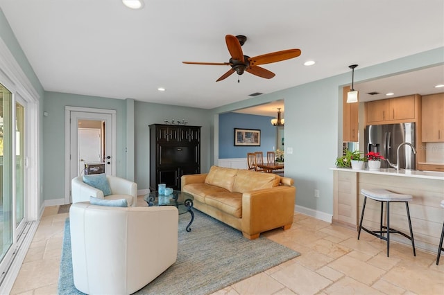 living room featuring ceiling fan and sink