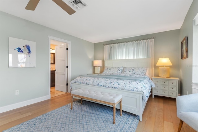 bedroom with ensuite bath, ceiling fan, and light hardwood / wood-style flooring