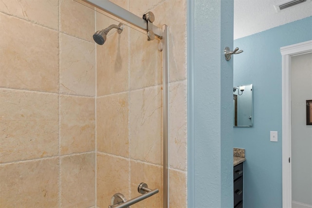 bathroom featuring vanity and a tile shower