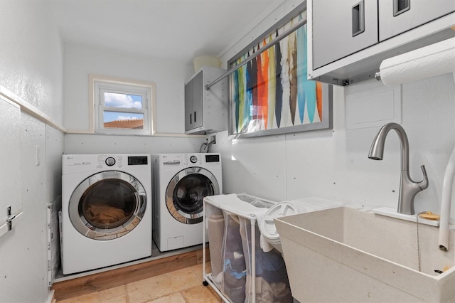 laundry room featuring cabinets, independent washer and dryer, and sink