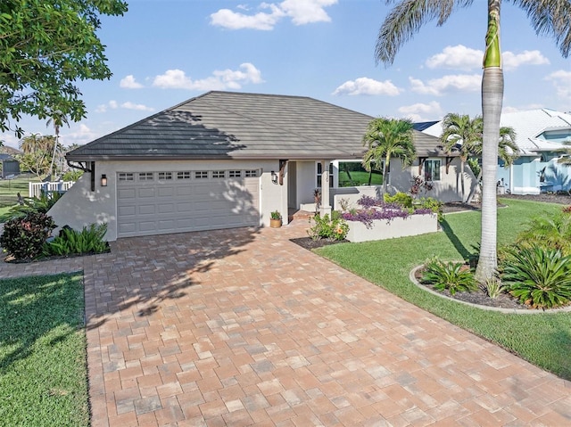 single story home featuring a front lawn and a garage