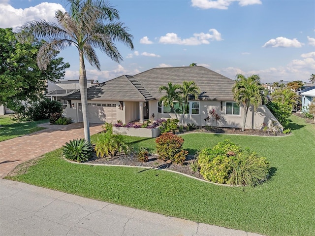 ranch-style home featuring a garage and a front lawn