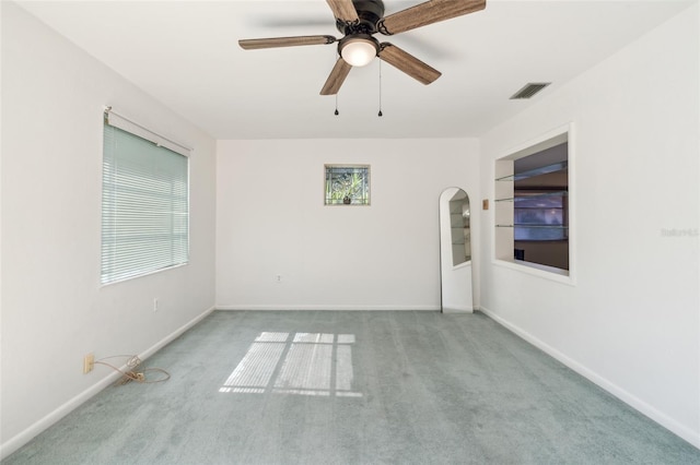 carpeted spare room featuring ceiling fan and built in features