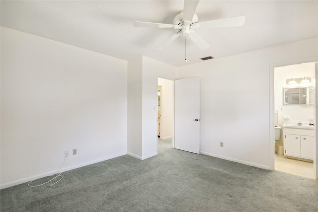 unfurnished bedroom featuring light carpet, ensuite bath, ceiling fan, and sink