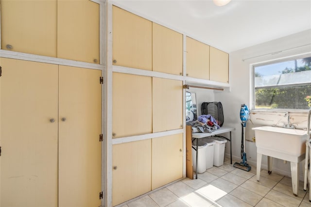 clothes washing area featuring light tile patterned flooring