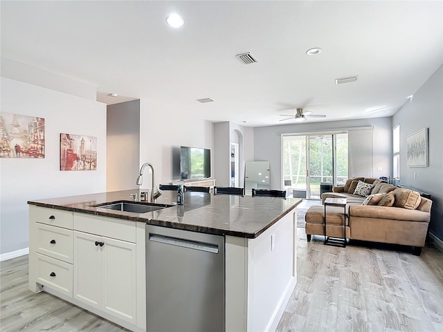 kitchen with a kitchen island with sink, visible vents, open floor plan, stainless steel dishwasher, and a sink