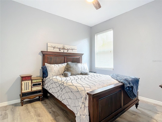 bedroom featuring a ceiling fan, wood finished floors, and baseboards