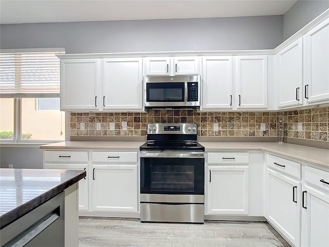 kitchen featuring backsplash, appliances with stainless steel finishes, light countertops, and white cabinetry