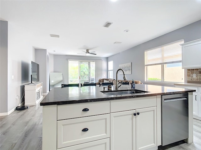 kitchen with visible vents, a sink, stainless steel dishwasher, open floor plan, and decorative backsplash