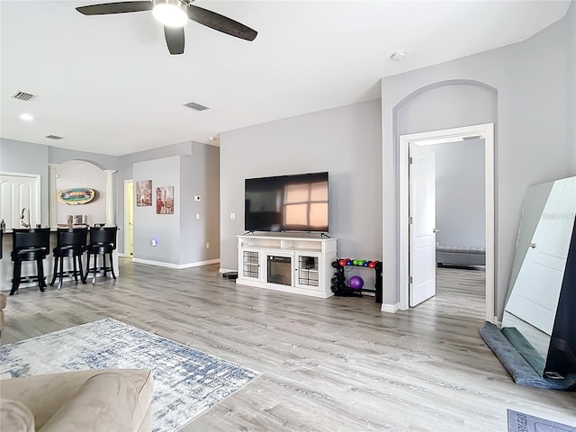 living room with wood finished floors, visible vents, and baseboards