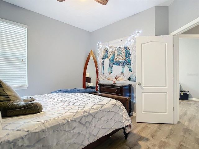 bedroom featuring baseboards, light wood-style flooring, and a ceiling fan