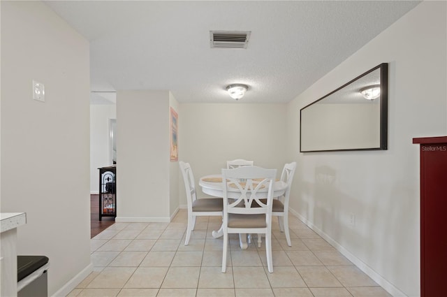 tiled dining room with a textured ceiling