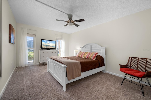 carpeted bedroom featuring ceiling fan and a textured ceiling