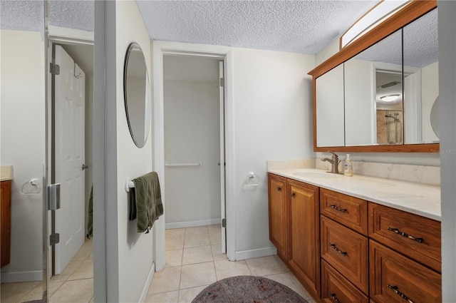 bathroom featuring tile patterned floors, vanity, and a textured ceiling