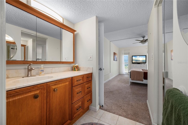 bathroom with tile patterned flooring, ceiling fan, a textured ceiling, and vanity