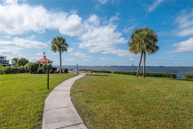 surrounding community with a gazebo, a lawn, and a water view