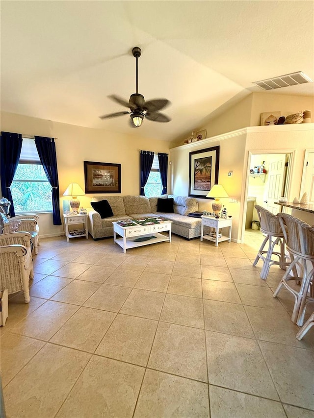 living room with ceiling fan, light tile patterned floors, and vaulted ceiling