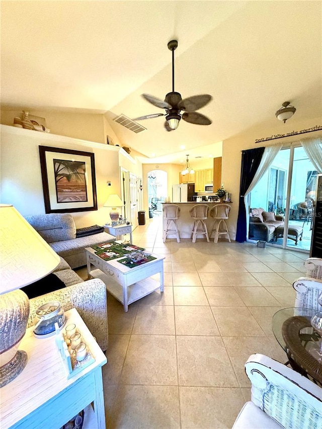 living room with vaulted ceiling, ceiling fan, and light tile patterned flooring