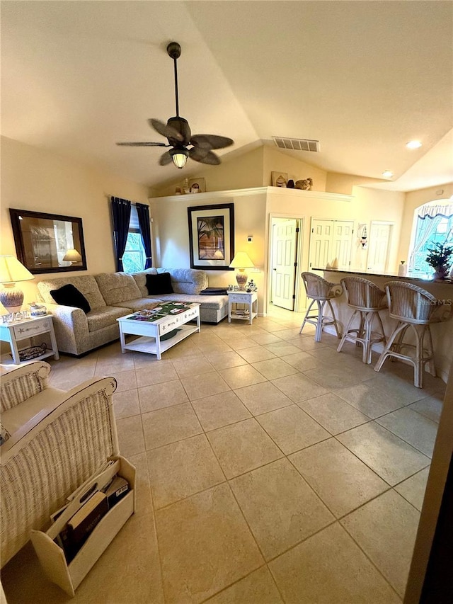 living room with ceiling fan, light tile patterned flooring, and vaulted ceiling