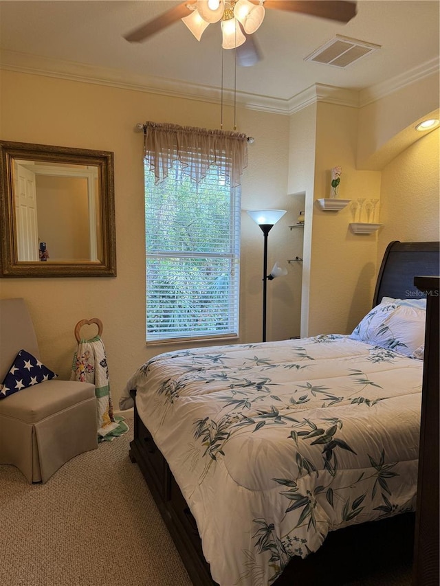 carpeted bedroom featuring ceiling fan and crown molding