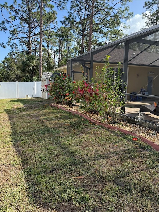 view of yard featuring a lanai and a shed