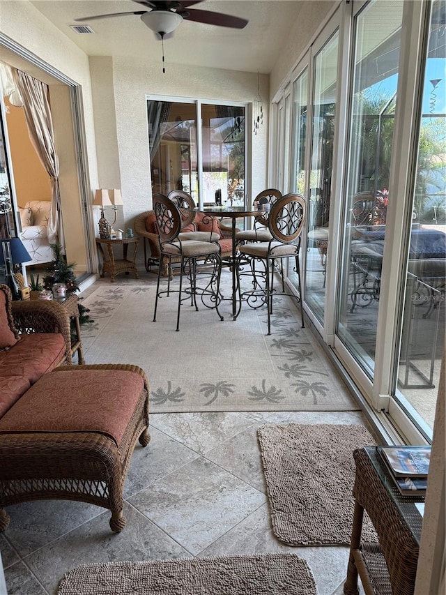 sunroom / solarium featuring ceiling fan