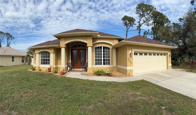 view of front of home featuring french doors, a front yard, and a garage