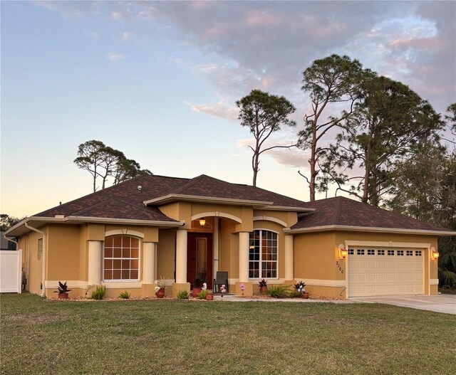 prairie-style house featuring a lawn and a garage