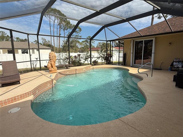 view of pool with pool water feature, glass enclosure, and a patio