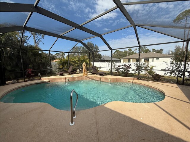 view of pool with pool water feature, a lanai, and a patio area