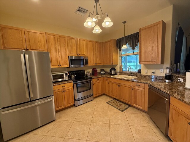 kitchen featuring pendant lighting, an inviting chandelier, sink, light tile patterned floors, and stainless steel appliances