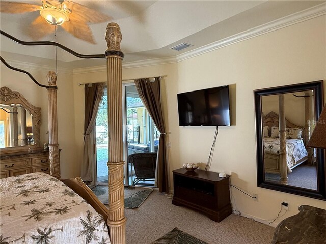 carpeted bedroom with a raised ceiling, ceiling fan, and crown molding