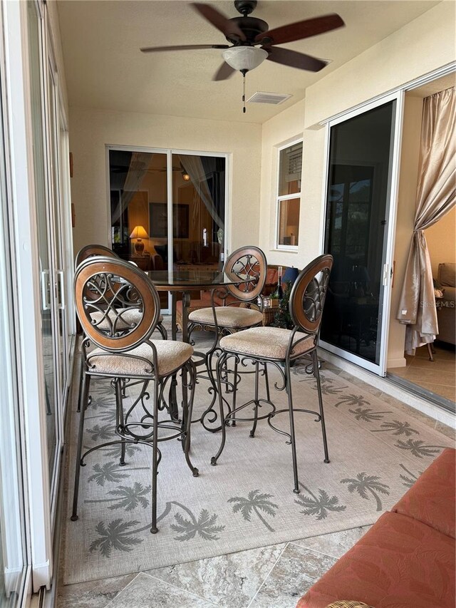 sunroom featuring ceiling fan