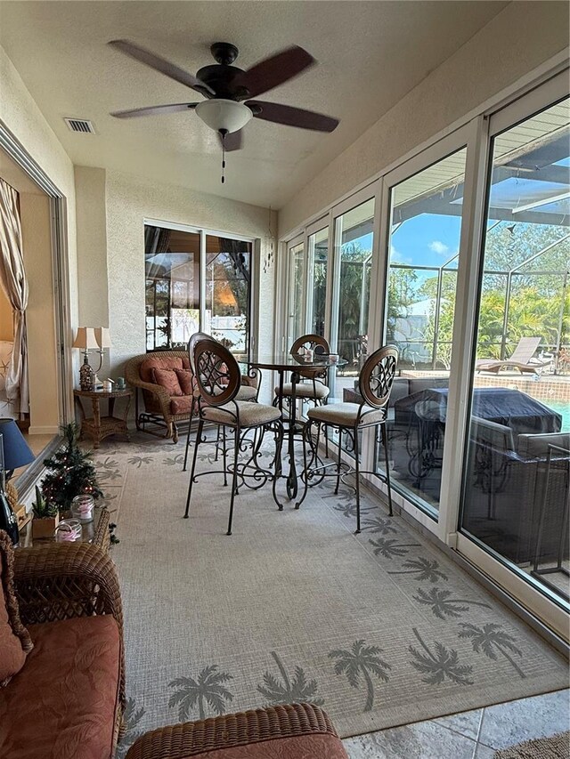 sunroom featuring ceiling fan