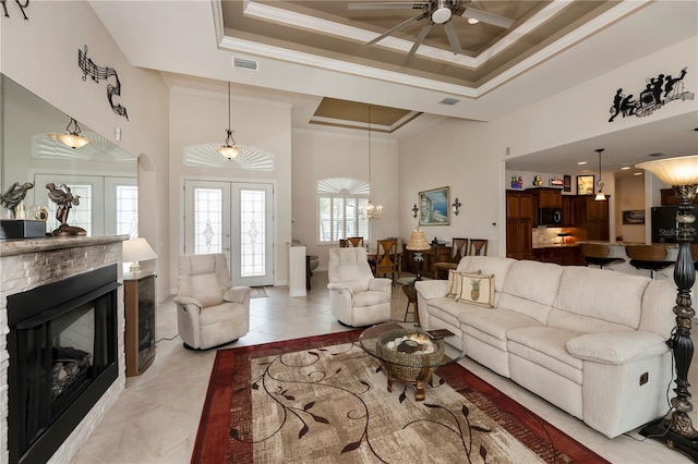 living room featuring ceiling fan with notable chandelier, french doors, a towering ceiling, and ornamental molding