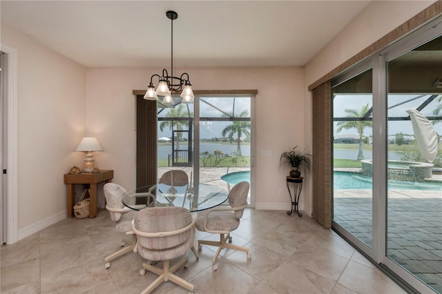 dining area with a water view, a wealth of natural light, and a notable chandelier