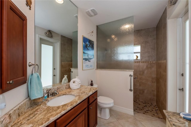 bathroom with toilet, vanity, and tiled shower