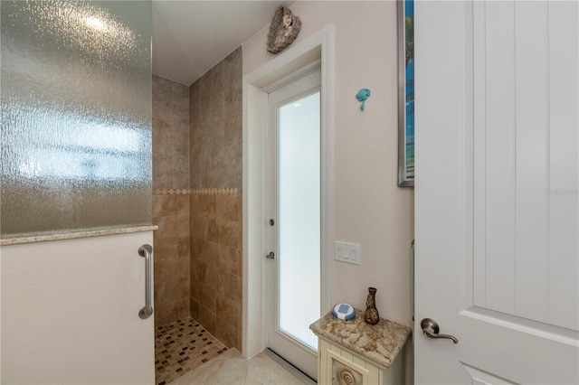 bathroom featuring tile patterned flooring and a tile shower