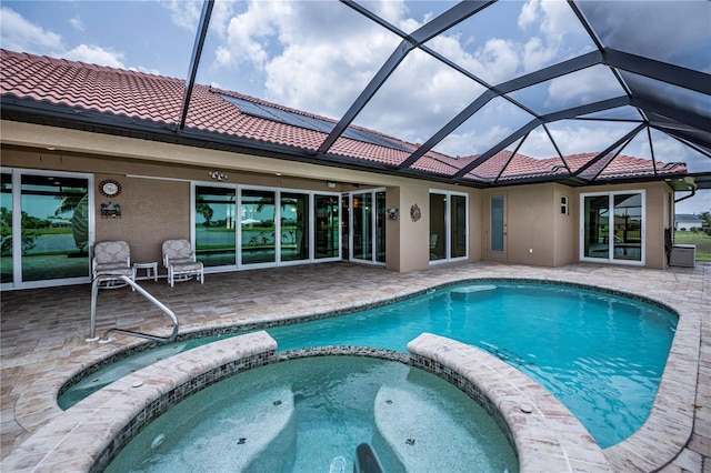 view of swimming pool with glass enclosure, a patio area, and an in ground hot tub