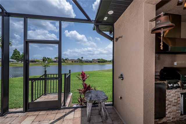 sunroom featuring a water view