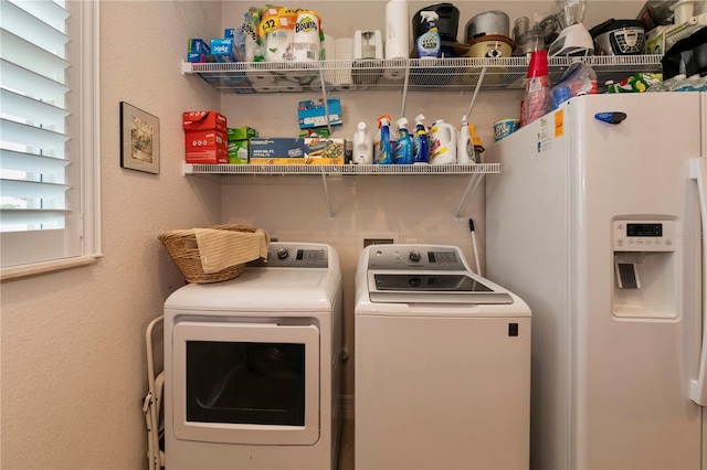 clothes washing area with washer and clothes dryer