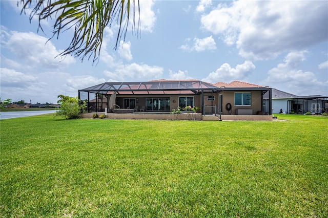 back of house with a yard, a water view, and glass enclosure