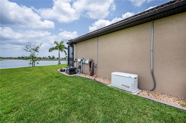 view of side of property with a yard and a water view