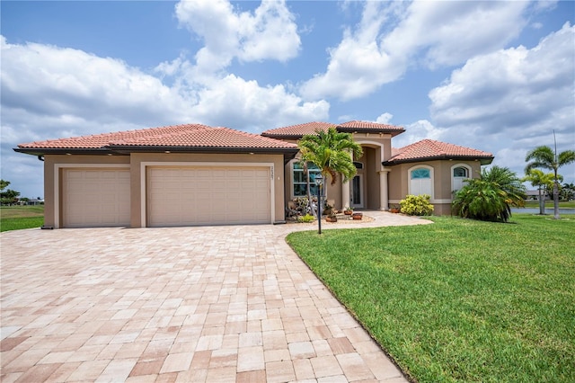 mediterranean / spanish-style house with a garage and a front lawn