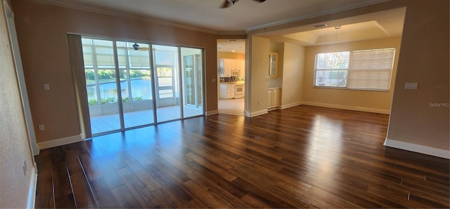 unfurnished room featuring ceiling fan, ornamental molding, and dark wood-type flooring