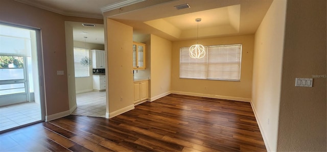 interior space with dark hardwood / wood-style flooring, a tray ceiling, and a chandelier