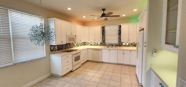 kitchen with decorative backsplash, white appliances, ceiling fan, sink, and white cabinetry