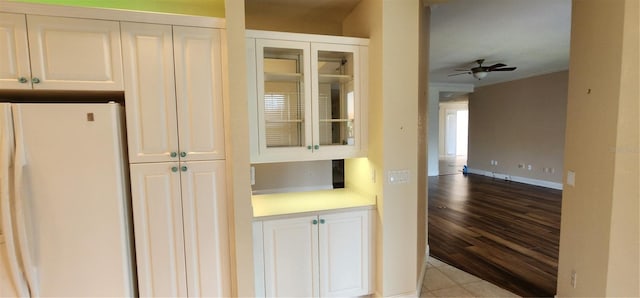 kitchen featuring white cabinets, ceiling fan, white refrigerator, and light wood-type flooring