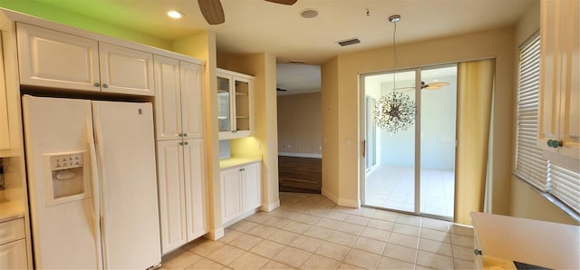 kitchen with pendant lighting, ceiling fan, white fridge with ice dispenser, light tile patterned flooring, and white cabinetry